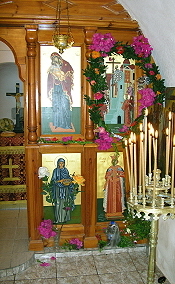 die Altarwand mit dem geschmückten Heiligenbild des Feiertages