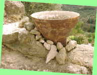 alter Tontopf schmiegt sich in eine schiefe Mauer